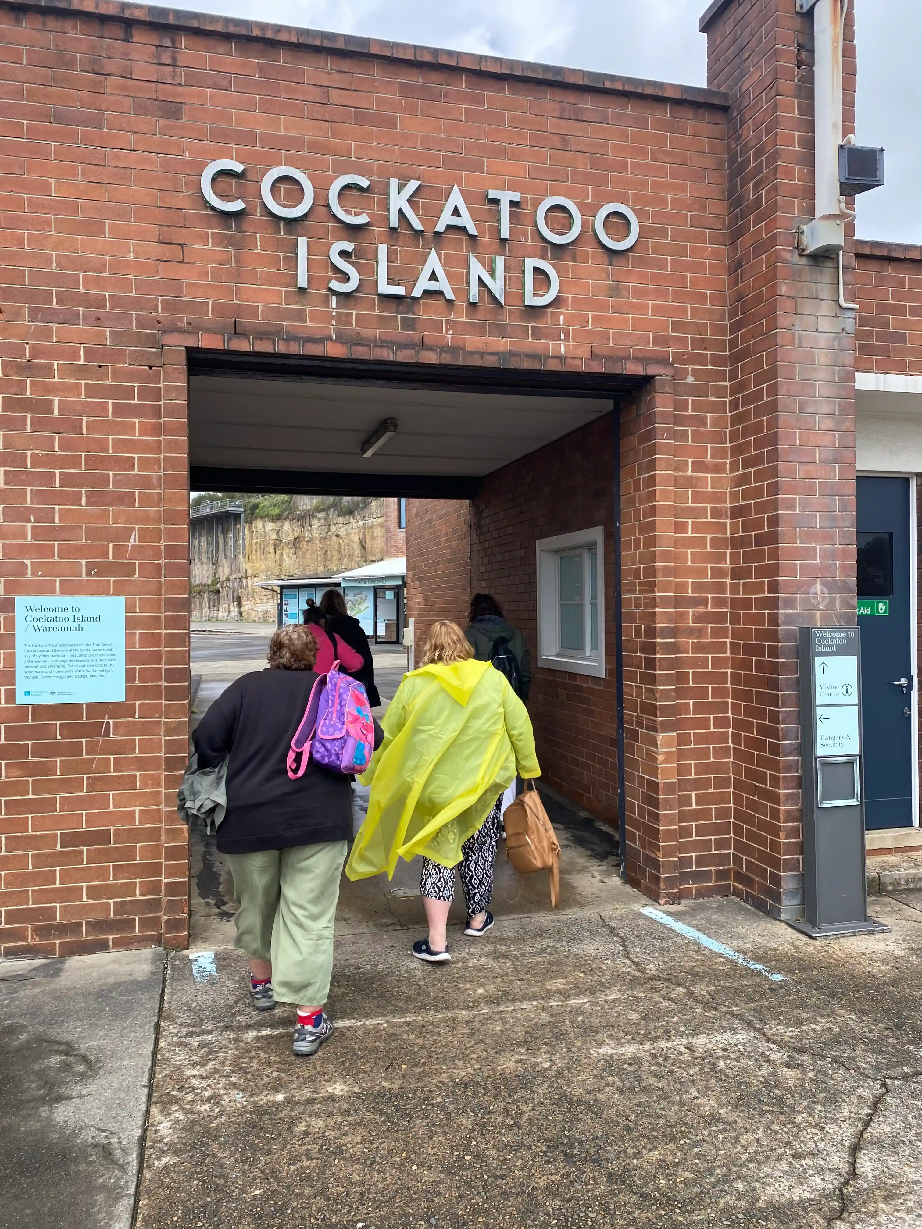 Two people from Access 2 Goals walking through the entrance to Cockatoo Island on a group day trip